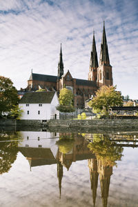 Uppsala cathedral reflecting in river fyris against sky