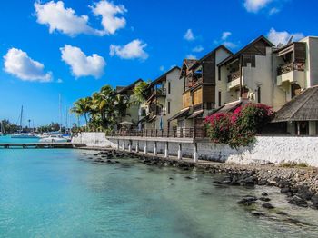 Houses by sea against blue sky