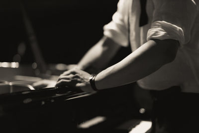 Midsection of man playing piano