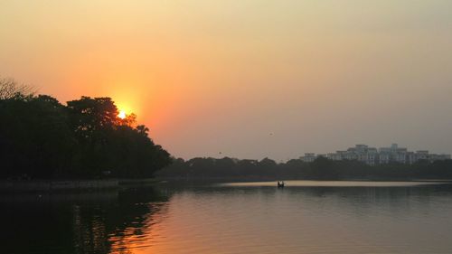Scenic view of lake against sky at sunset