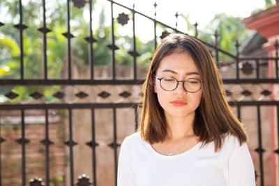 Woman looking down against gate