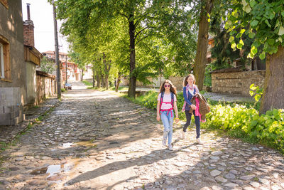 Rear view of women walking on footpath