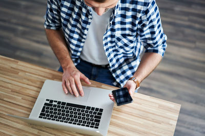 High angle view of man using laptop on table