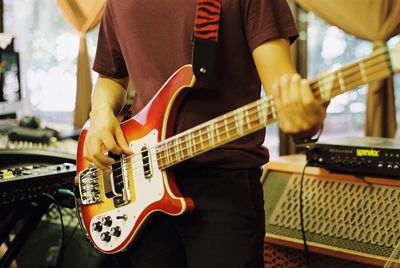 Midsection of man playing guitar