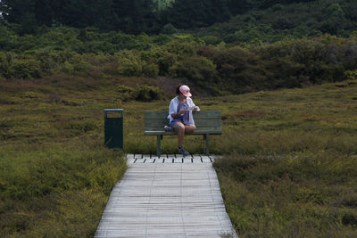 Rear view of woman walking on grassy landscape
