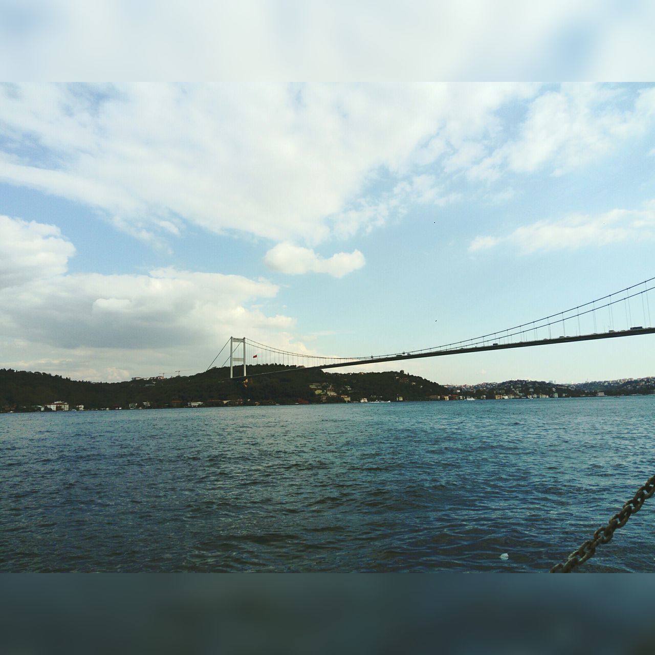 architecture, connection, bridge - man made structure, suspension bridge, water, sky, built structure, transportation, river, travel destinations, no people, outdoors, travel, cloud - sky, day, waterfront, nature, city, beauty in nature