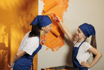 Side view of smiling couple standing against wall