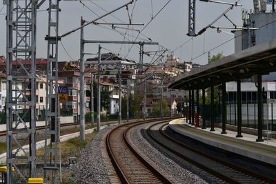 Railroad station platform in city against sky