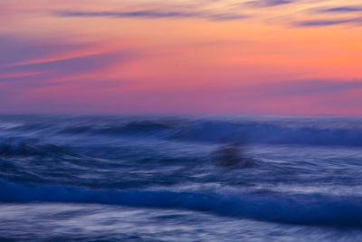 Scenic view of sea against dramatic sky during sunset