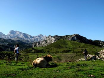 People in mountains against clear blue sky