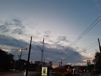 Low angle view of illuminated street lights against sky