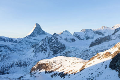 Scenic view of snowcapped mountains against clear sky