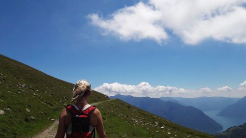 Rear view of woman looking at mountains against sky