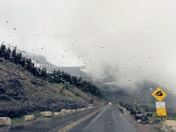 Road seen through wet glass window