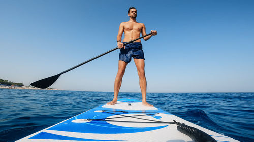 Man on stand up paddle.