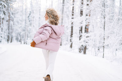 Full length of woman standing on snow covered field