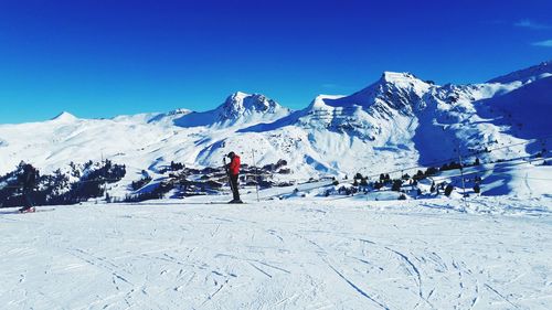 Scenic view of snowcapped mountains against blue sky