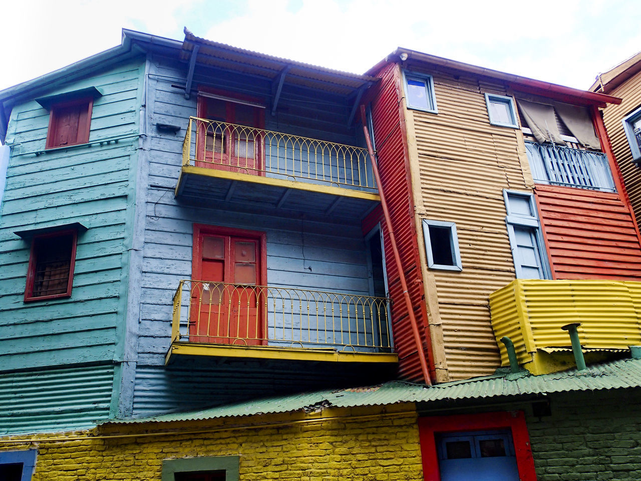 LOW ANGLE VIEW OF MULTI COLORED HOUSES