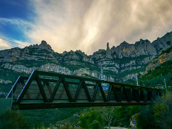 Bridge over mountains against sky