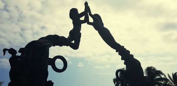 Low angle view of silhouette hand against sky