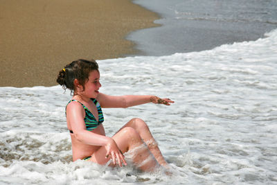 Girl in bikini sitting at beach