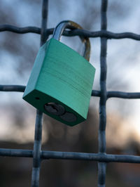 Close-up of padlocks hanging on fence