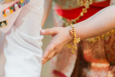 Midsection of bride touching bridegroom legs
