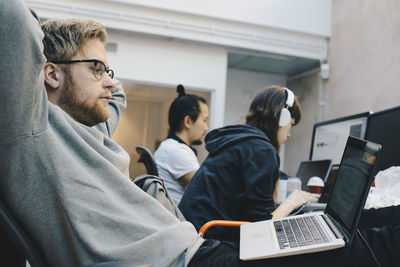 Side view of computer programmers working in office