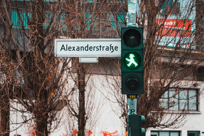 Road sign by bare trees