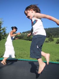 Mother and son jumping on trampoline