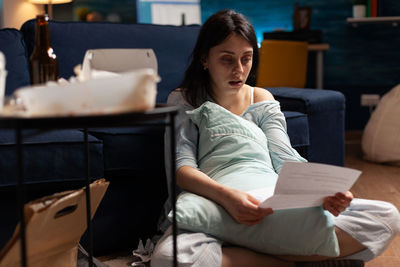 Young woman sitting on sofa at home