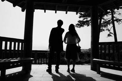 Rear view of couple standing against railing