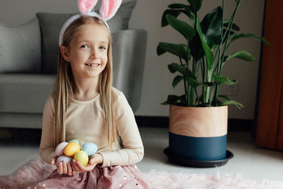 Portrait of young woman holding potted plant