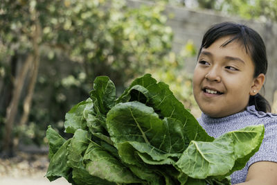 Close-up of cute girl holding leaf