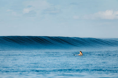 Man surfing in sea against sky