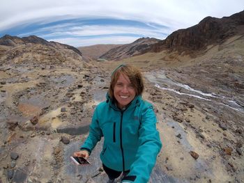 Portrait of smiling young woman standing on mountain