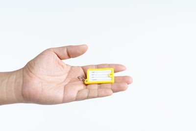 Close-up of hand holding eyeglasses against white background