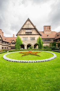 Lawn in front of building against sky