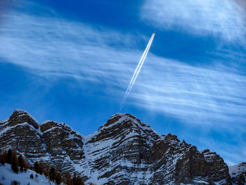 Low angle view of vapor trail against blue sky