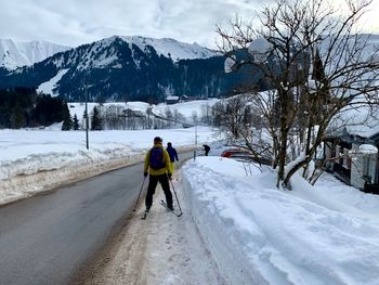 Rear view of men walking on snow covered mountain