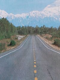 Scenic view of road by mountains against sky