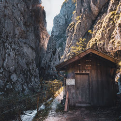 House on rock formation amidst buildings