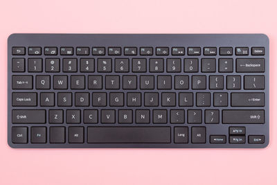 Close-up of keyboard over pink background