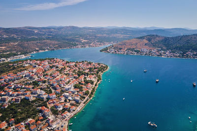 High angle view of city by sea against sky