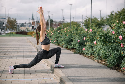 Full length of woman exercising on footpath