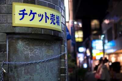 Close-up of illuminated sign in city at night