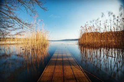 Pier amidst lake against sky