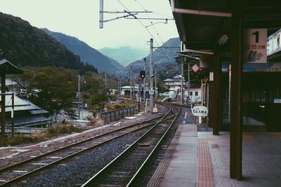 Railroad tracks by buildings against sky