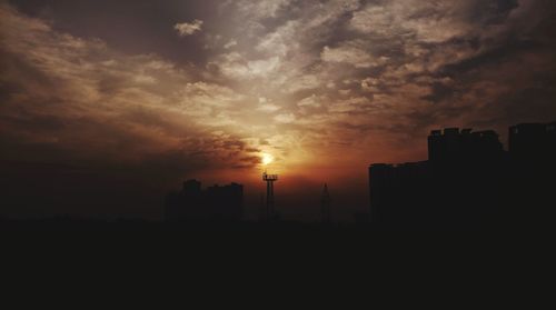 Silhouette buildings against sky during sunset