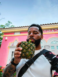 Full length of man holding building against sky